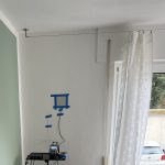 Man sieht die Wärmestrommessplatte an der Wand und den Datenlogger.